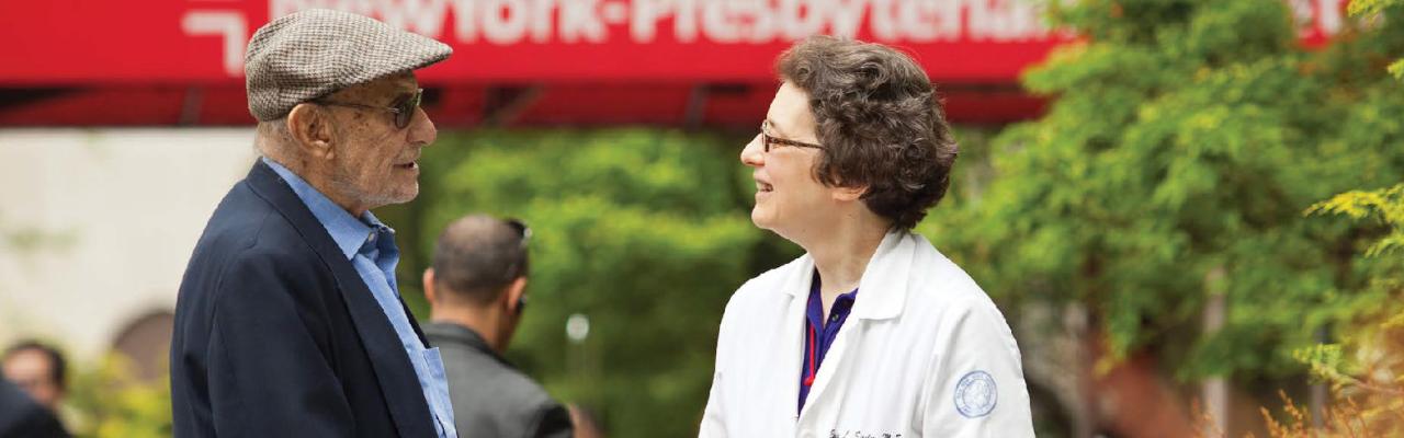 An older adult shakes hands with a geriatrician outside of the hospital.